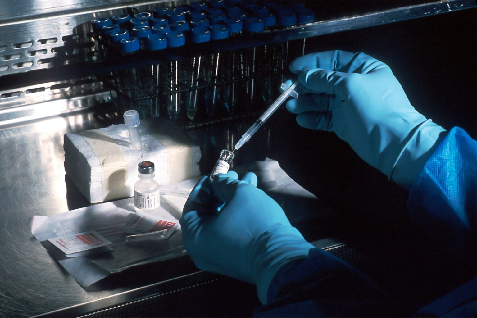 Researcher testing sample tube with syringe