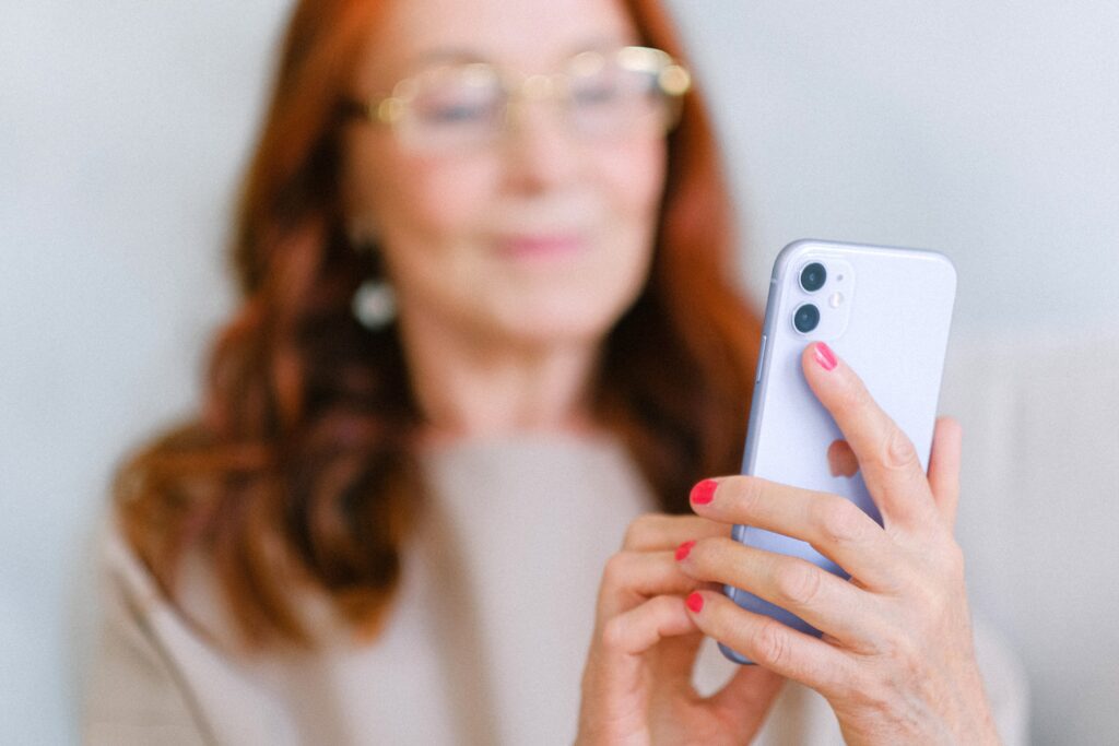 Older woman messaging on modern smartphone