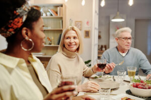 happy mature woman sitting at a festive holiday table with her family