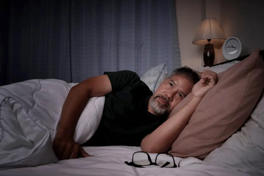 Man lying in bed with insomnia