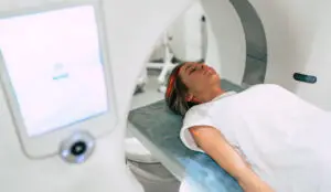 Young woman patient is ready to do magnetic resonance imaging in the modern hospital laboratory