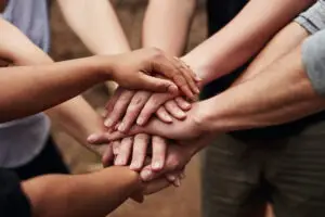 Cropped shot of a group of unrecognisable people joining hands in solidarity out in nature