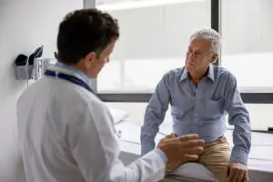 Doctor talking to a male patient in a consultation at the office