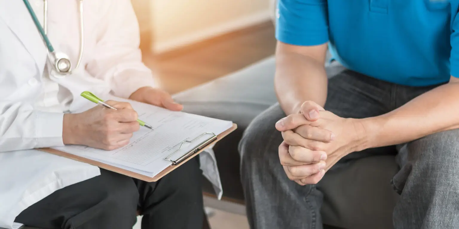 close up of clipboard doctor having consultation with male patient