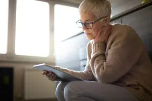 woman looking at an ipad sitting down in home