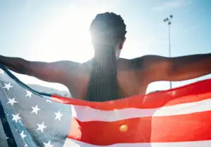 American athlete holding American flag from the back