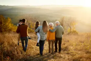 Back view of multi-generation family taking a walk on a hill.