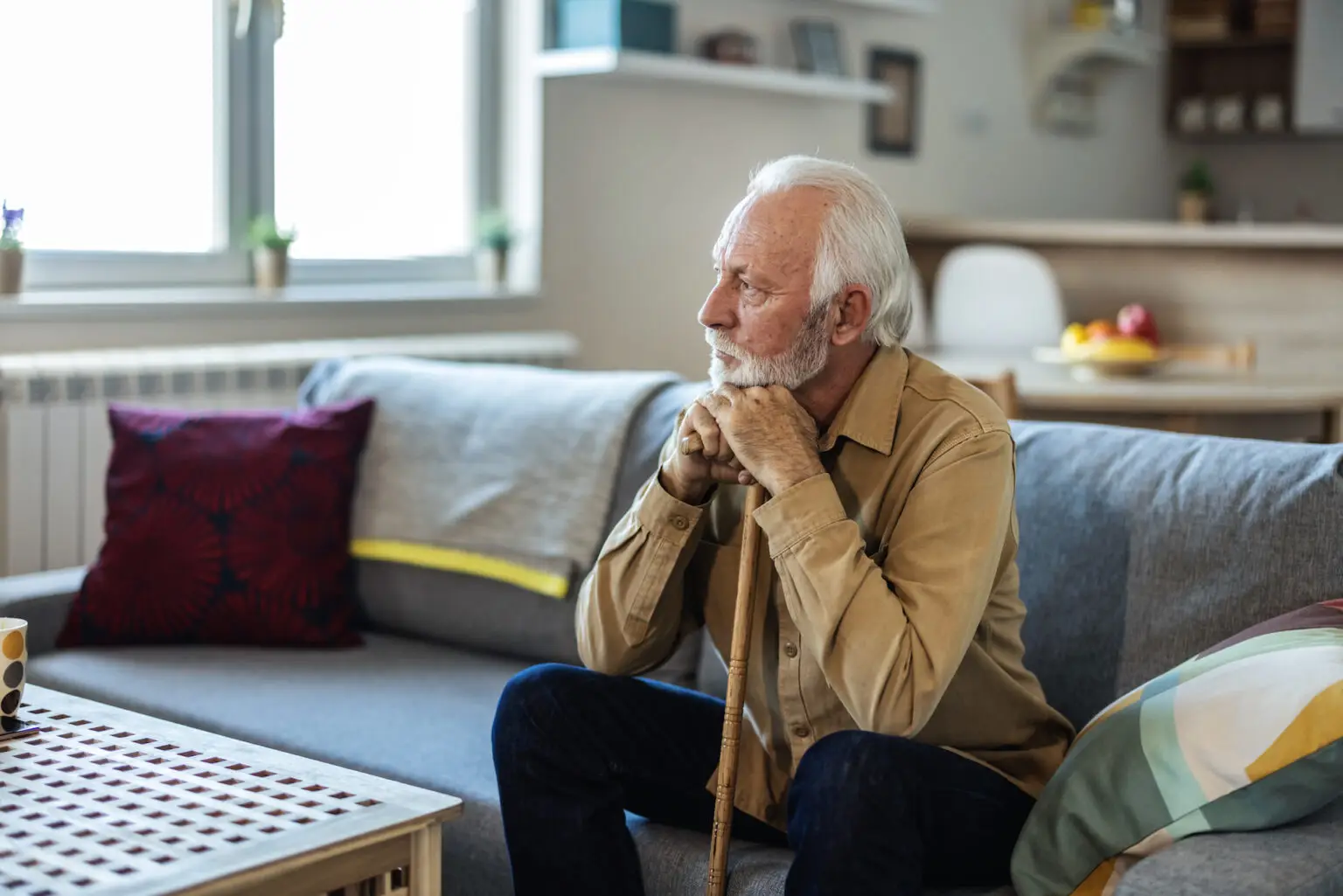 close up of older man sitting in his living room thinking