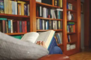 woman reading a book in an armchair in a reading room