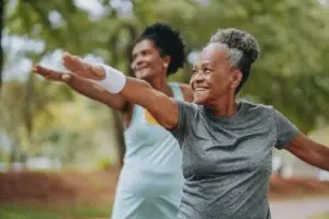 Two women friends doing exercises together outdoors