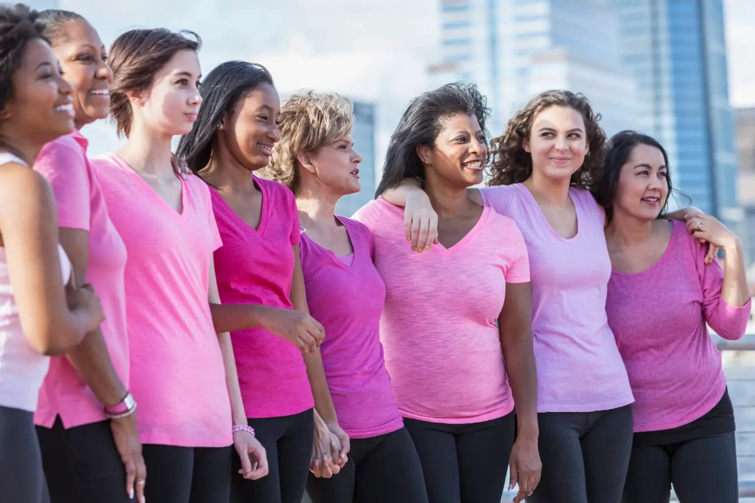 a group of moms and their children in pink shirts to celebrate Breast Cancer Awareness Month outside