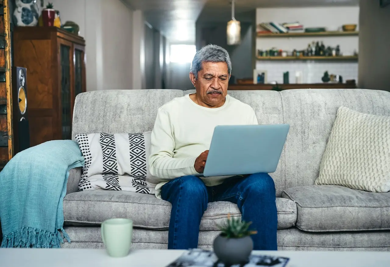 Shot of a senior man using a laptop on the sofa at home