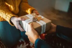 Hands giving wrapped a gift close-up