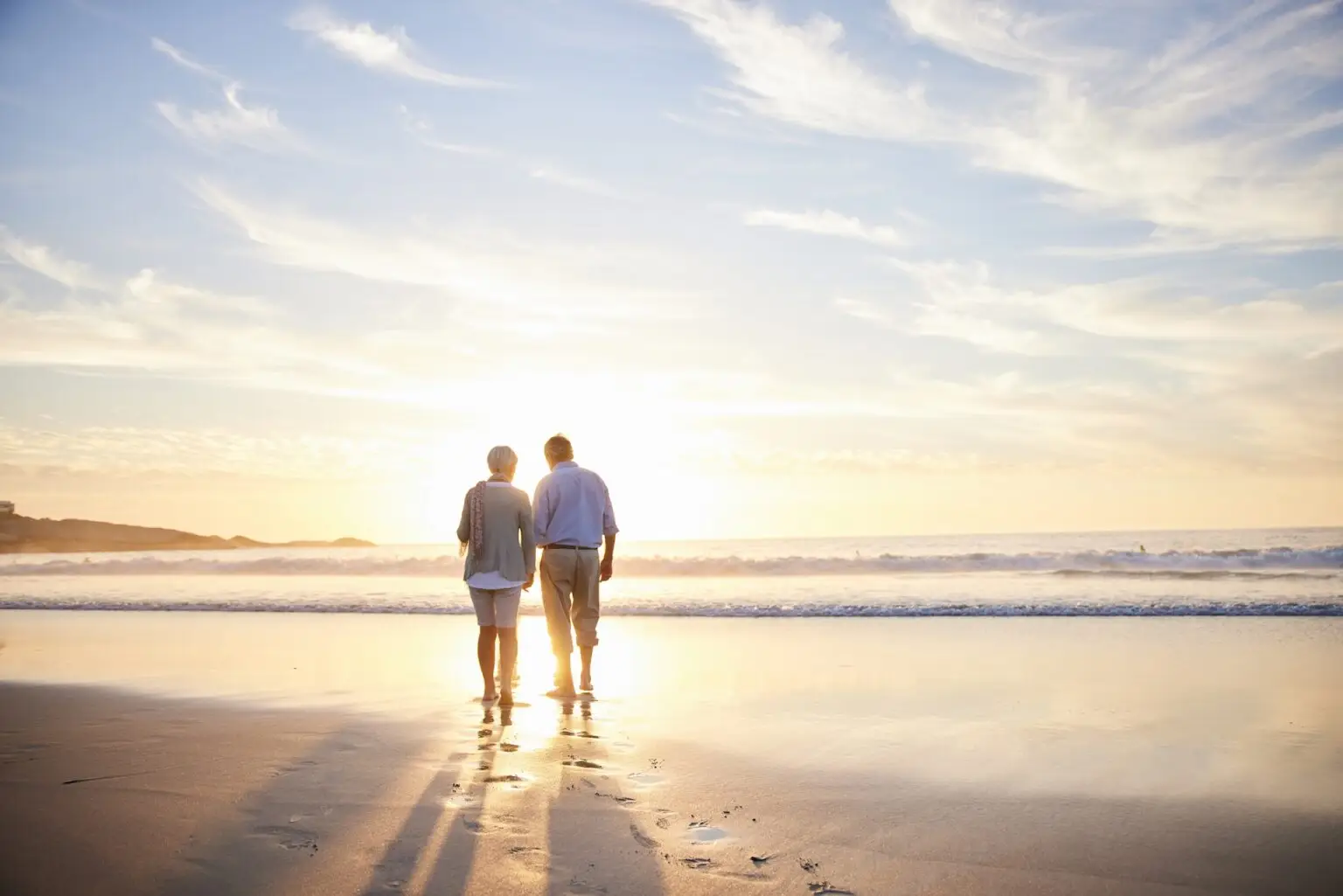 couple walking on the beach during sunset