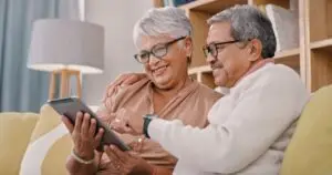 older couple looking at tablet on the couch at home