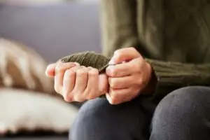 close up of woman's hands in a green sweater