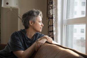 Woman looking out the window at home