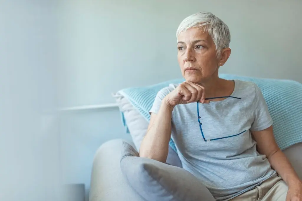 older woman sitting on couch gazing away