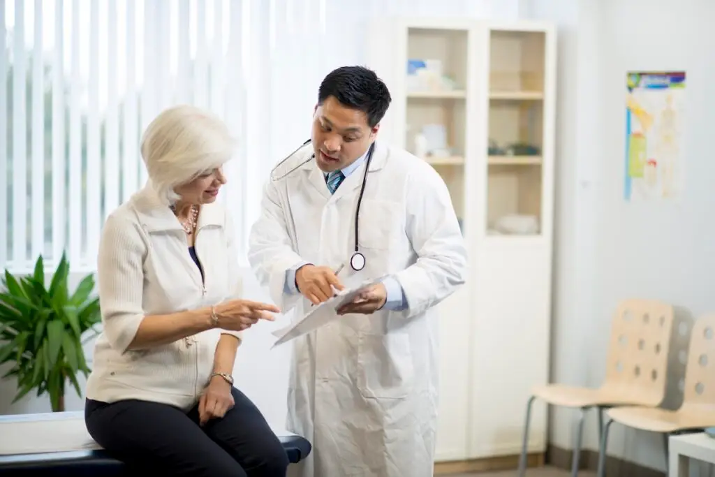 male doctor consulting with an older female patient in office