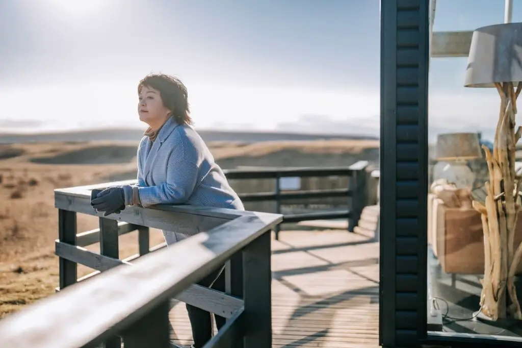 older woman leaning on the terrace looking at scenery