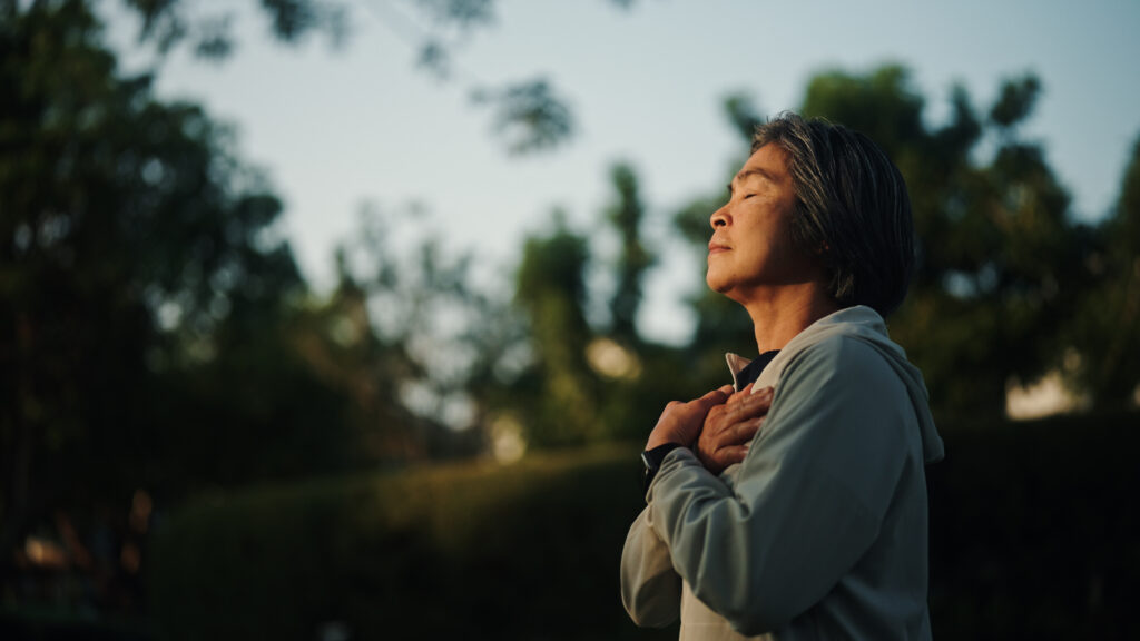 Senior woman meditating outdoors.