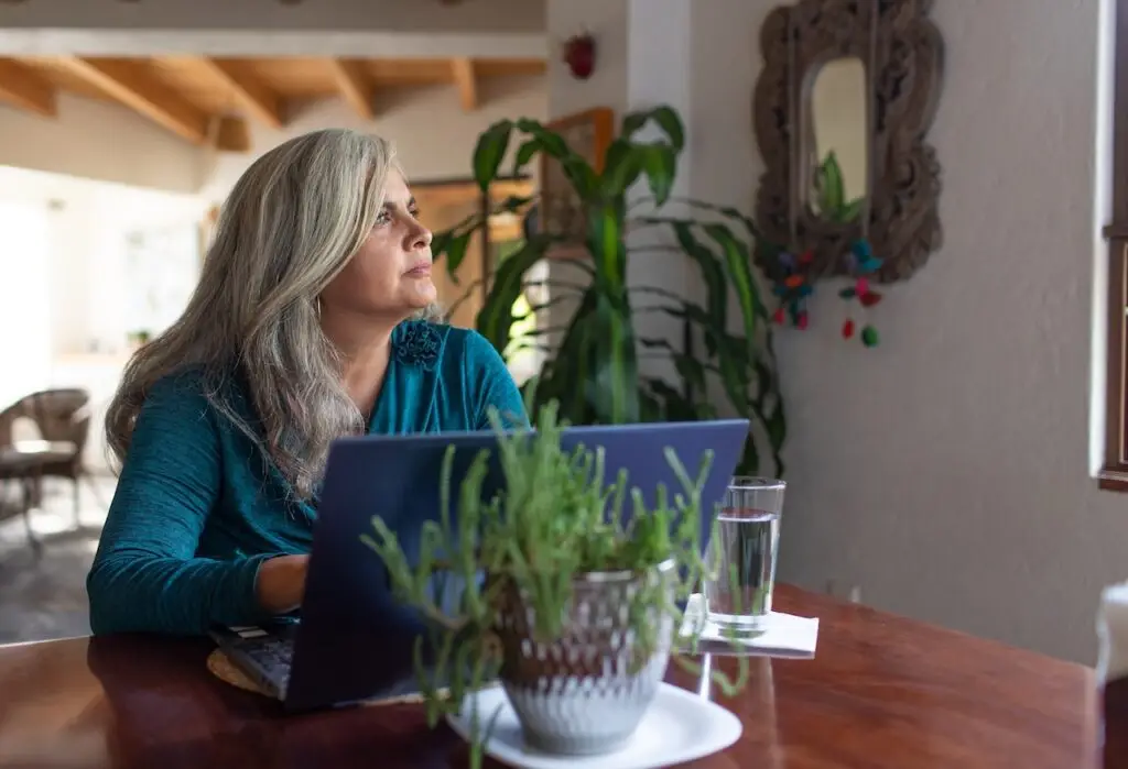 woman with grey hair on computer looking away