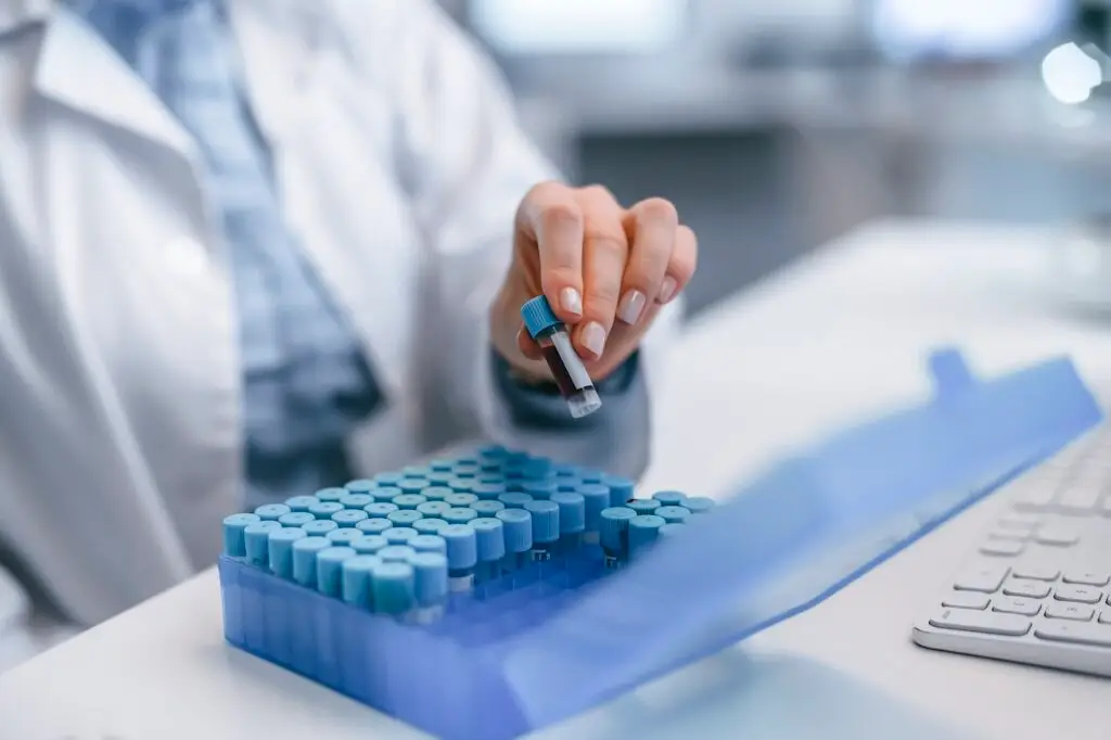 medical professional handling test tubes in lab