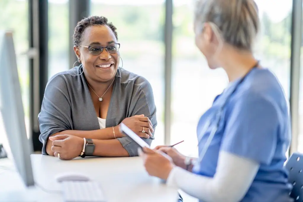 woman sitting with a medical professional consulting on health