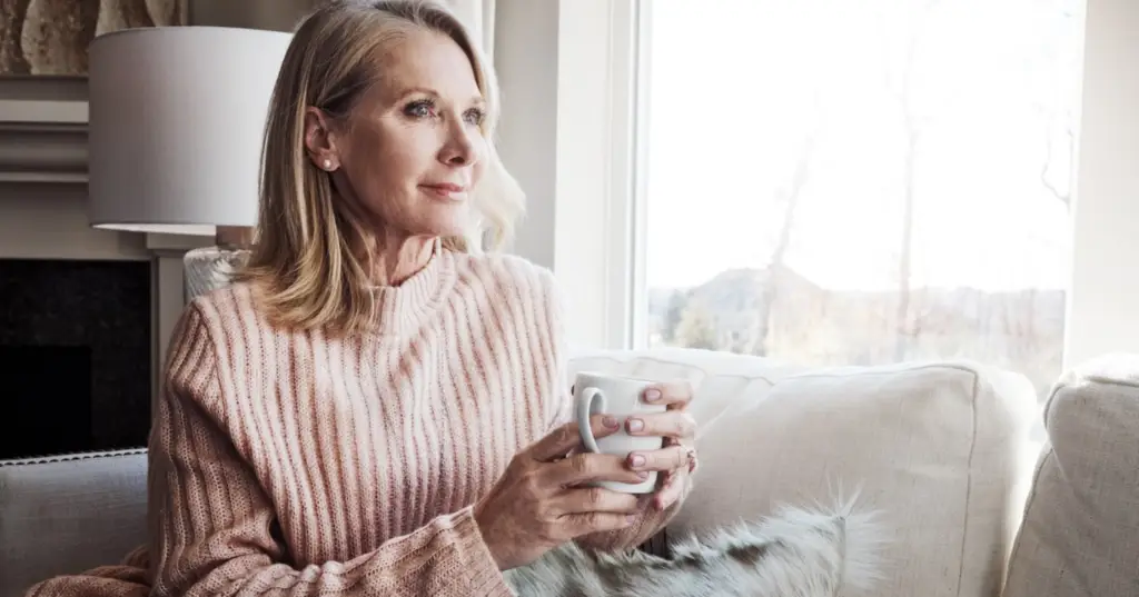 Shot of a mature woman relaxing on the sofa at home with a cup of coffee