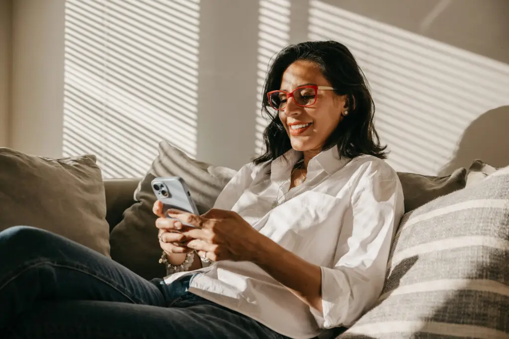 woman relaxing on the couch looking at phone