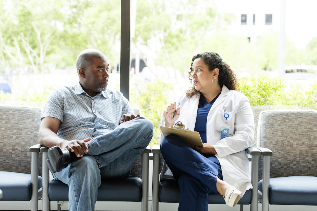 doctor sitting with older male patient