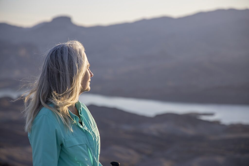 older woman looking at on mountain with lake view