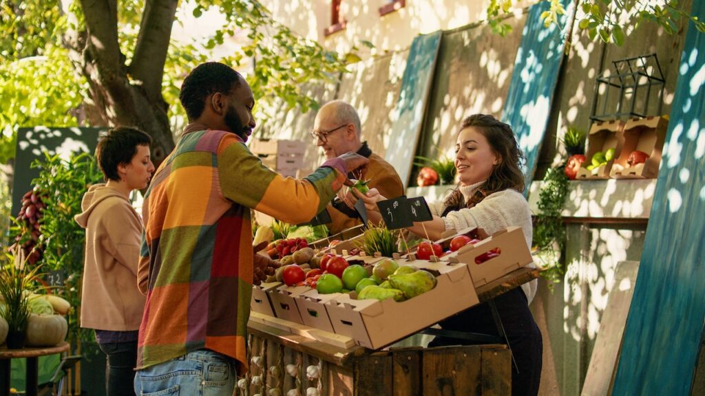 people shopping at farmer's market getting produce