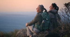 two woman sitting after a hike with view