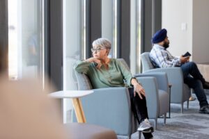 older woman sitting in waiting room looking at the window