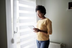 a woman looking at her phone next to a window