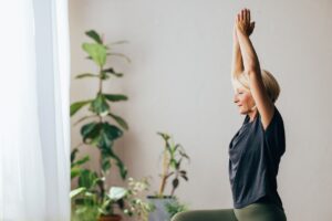 older woman with arms raised practicing yoga
