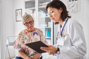 Female doctor with patient at clinic. They are sitting in examination room.
