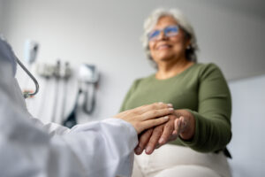 Doctor holding the hand of a senior patient at the hospital
