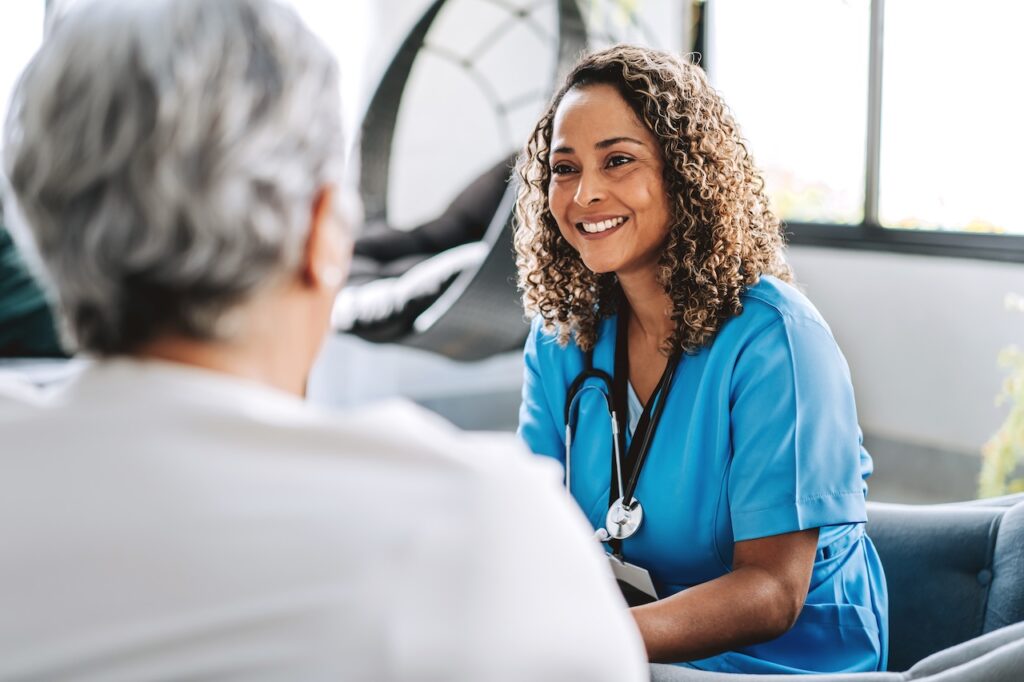 Healthcare professional talking to patient at home