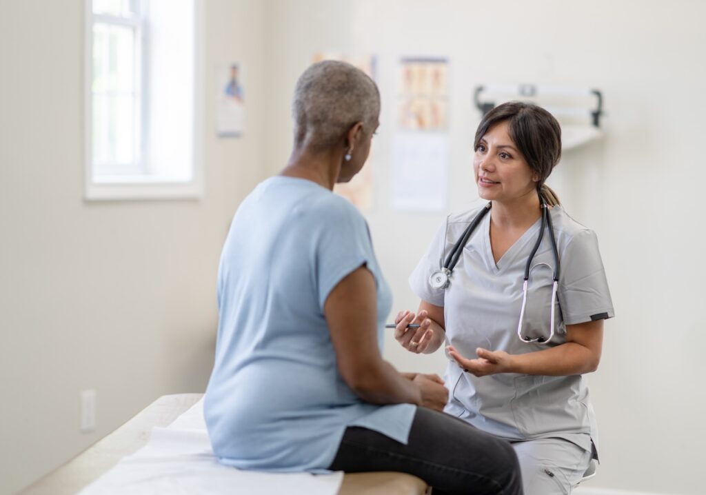 a woman speaking with doctor in a clinic asking questions