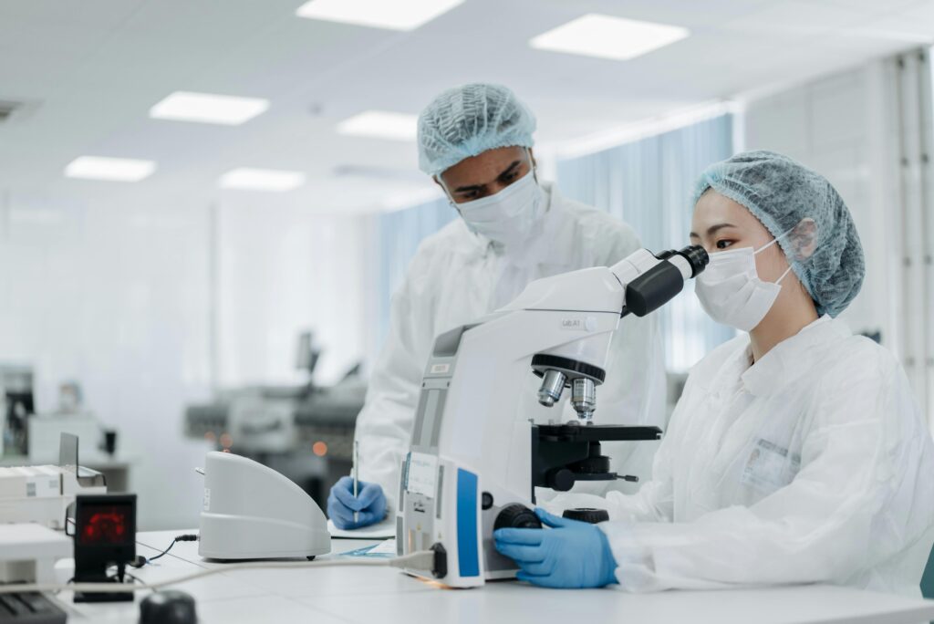 Female Doctor Looking Through Microscope While Testing.
