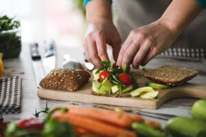 Adding fresh cherry tomatoes to sandwich