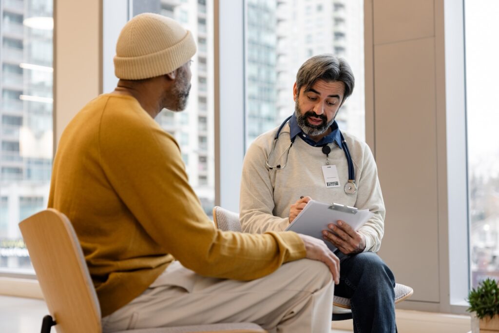 doctor talking to patient with a clipboard in a clinical setting