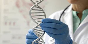 Doctor with a DNA model showing how insurance covers genetic testing for breast cancer.