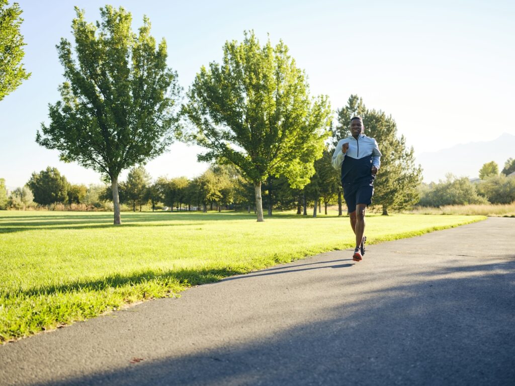 A mature black man, exercising in a park in the morning.