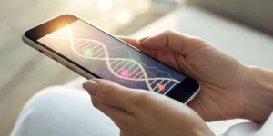 A person holding a smartphone with an app showing info for breast cancer genetic testing.