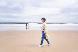 Side view of a relaxed mature woman walking on the beach