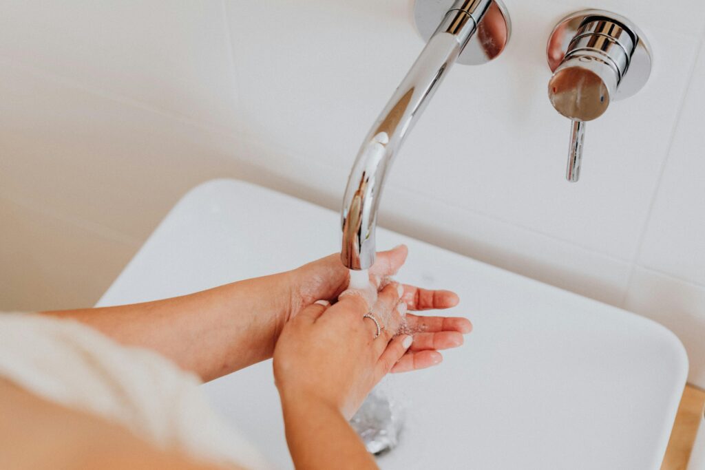 close up of a woman washing her hands in a sink