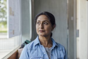 woman looking away peering out a window